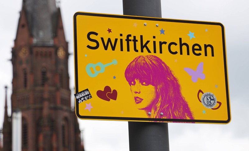 Ein Ortsschild namens Swiftkirchen statt Gelsenkirchen und einem Konterfei der Sängerin Taylor Swift, die im Juli drei Konzerte in der Arena auf Schalke gibt,