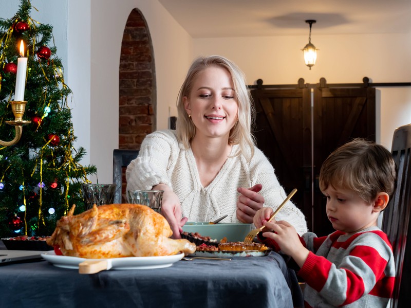 Eine Mutter und ihr Kind sitzen an Weihnachten am Esstisch