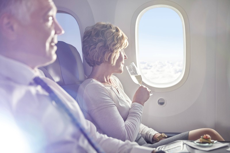 Frau beim Trinken im Flugzeug