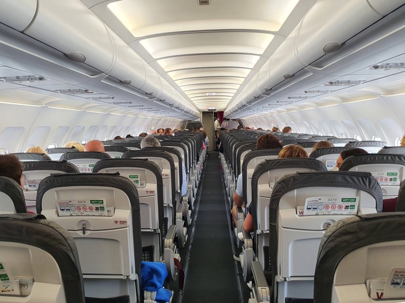 Der Innenraum eines Flugzeugs ist auf dem Bild zu sehen und es geht um Tipps für einen Langstreckenflug.
