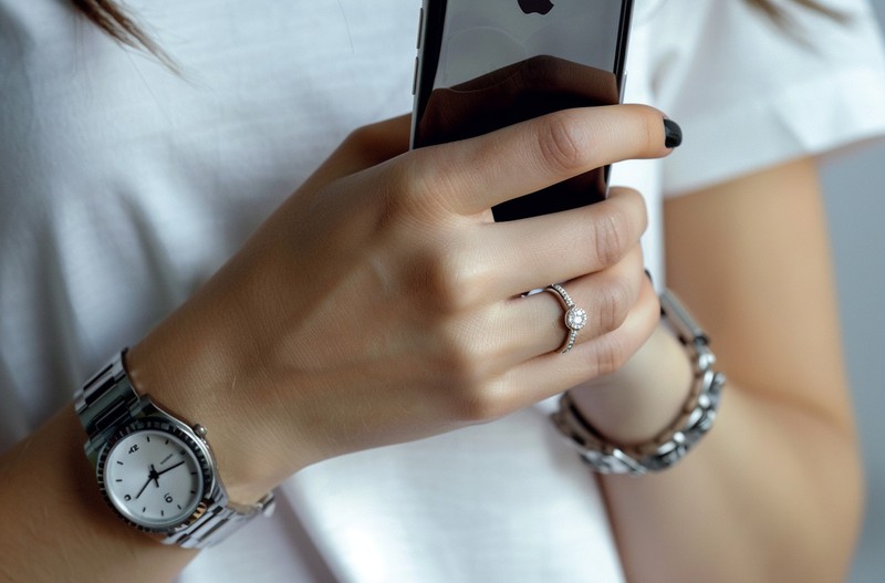Dieses Bild zeigt eine Frau, die ein Smartphone in der Hand hält, wobei im Ausland teure Roaming-Gebühren anfallen können.