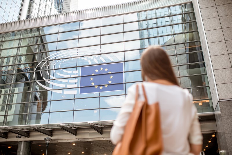 Frau steht vor dem EU-Parlament in Brüssel