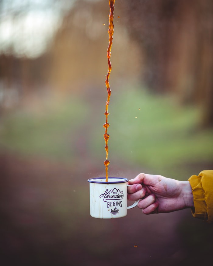 Reisender, der einen wiederverwendbaren Kaffeebecher in der Hand hält