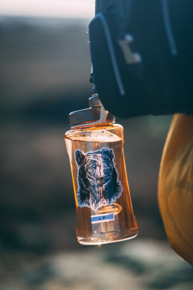 Nachhaltige Trinkflasche, die für eine Reise am Rucksack befestigt wurde