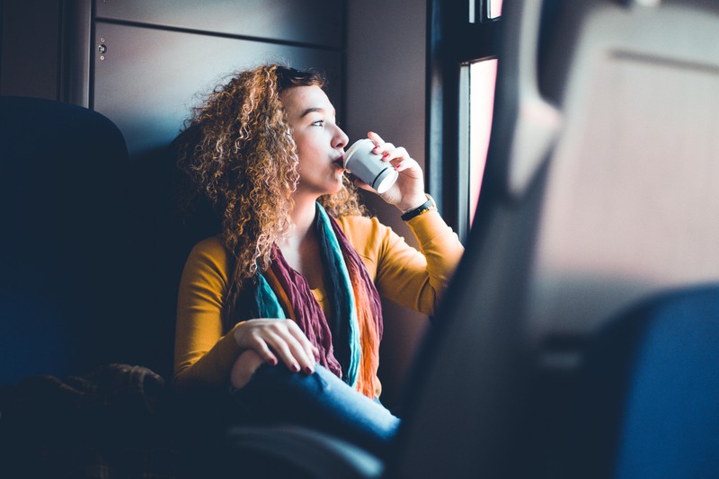 Frau trinkt Kaffee im Zug