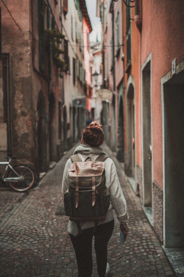 Eine Frau geht im Urlaub allein durch eine Gasse
