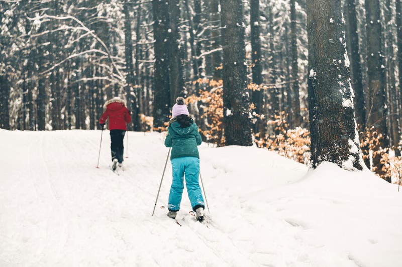 Schwestern in verschneiter Winterlandschaft auf Langlauf-Loipen-ski