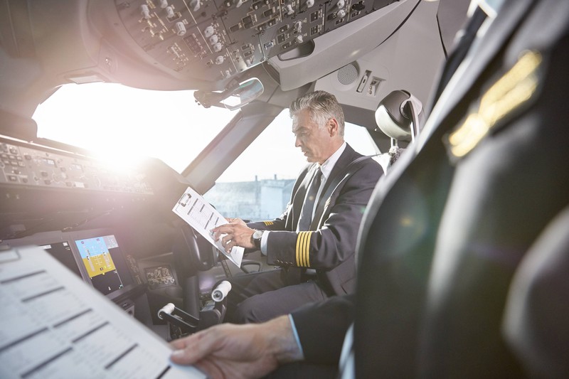 Piloten eines Flugzeuges studieren den Speiseplan, da sie nicht dasselbe essen dürfen