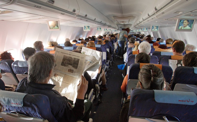 Bleib mit der Zeitung im Flugzeug auf deiner Seite, ohne die umliegenden Nachbarn damit zu belästigen.
