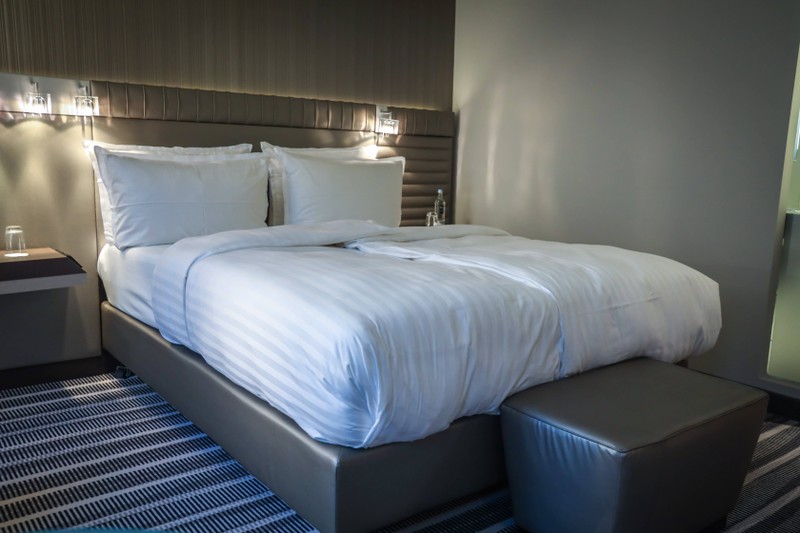 Ein Hotelbett mit einer Überdecke, was in Hotels zum Leid der Gäste nur selten gewaschen wird.