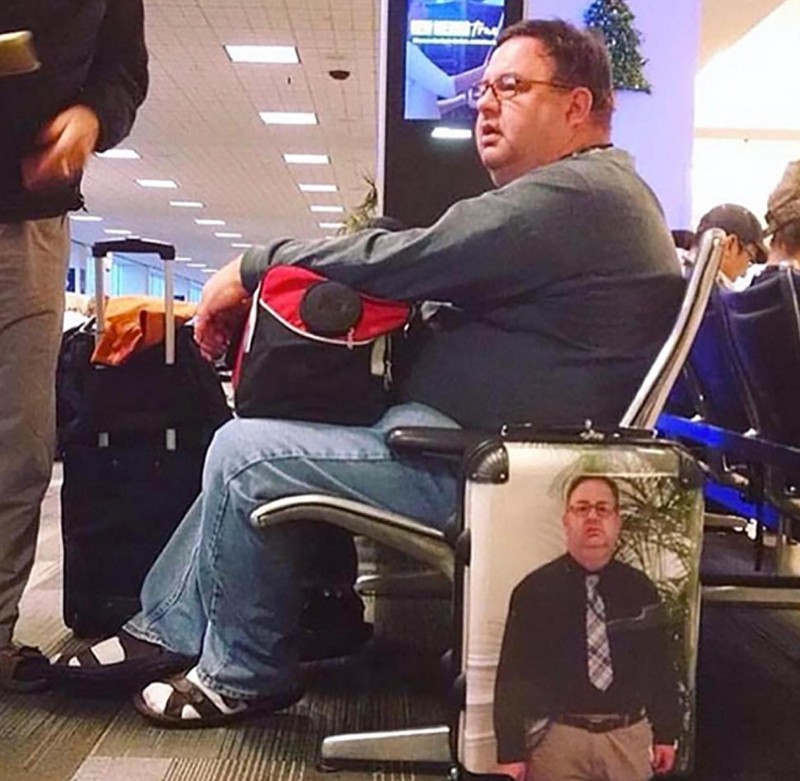 Der Mann ist auf seinem eigenen Koffer als Aufruck.