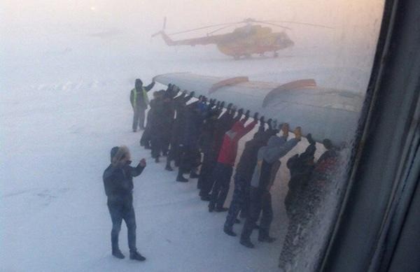 Ein verrücktes Foto, wie Leute in Russland ein Flugzeug anschieben