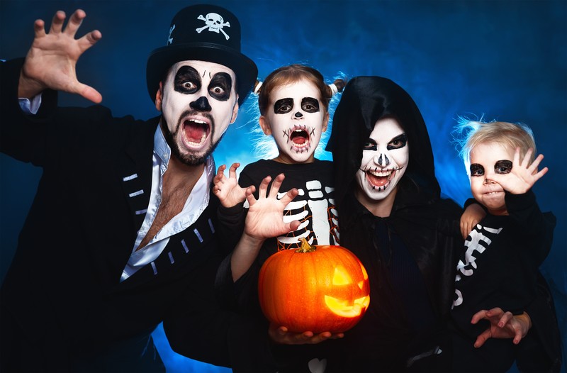 Zu sehen ist eine Familie, die sich für Halloween verkleidet hat.