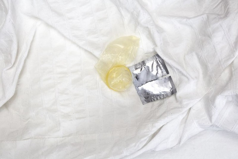 Ein benutztes Kondom in einem Bett eines Hotelzimmers