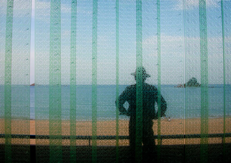 Ein Mann steht auf einem Balkon in einem Hotel und schaut auf die Landschaft