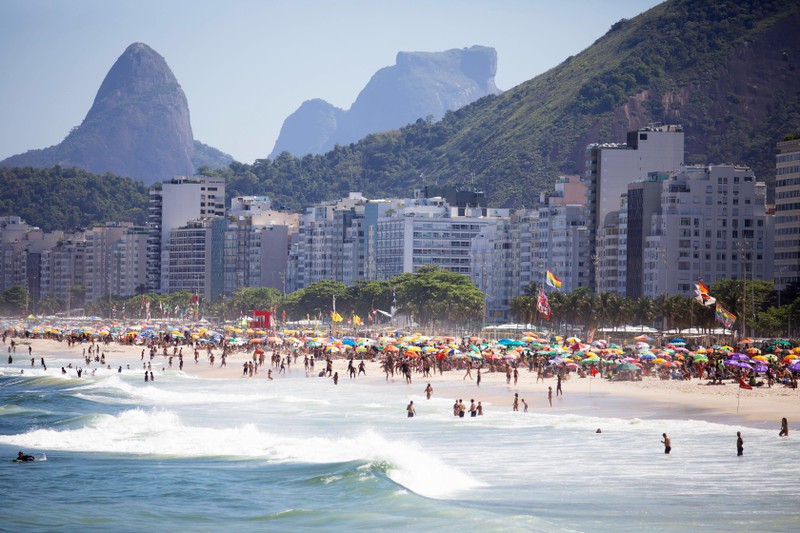 An der Copacabana gibt es viele Touristen und Touristinnen, die in Rio de Janeiro das Leben genießen