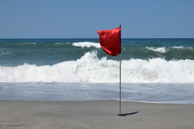 Am Strand warnen verschiedene Flaggen vor dem Zustand des Meeres.