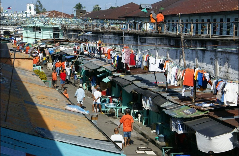 Straße im Gefängnis von New Bilibid mit Geschäften voller Insassen, die ihre Einkäufe tätigen.