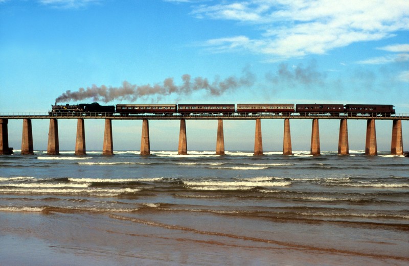 Der ehemalige Outeniqua Choo-Tjoe überquert die Mündung des Kaaimans River bei auflaufender Flut in Wilderness auf dem Weg zur Garden Route-Stadt Knysn.