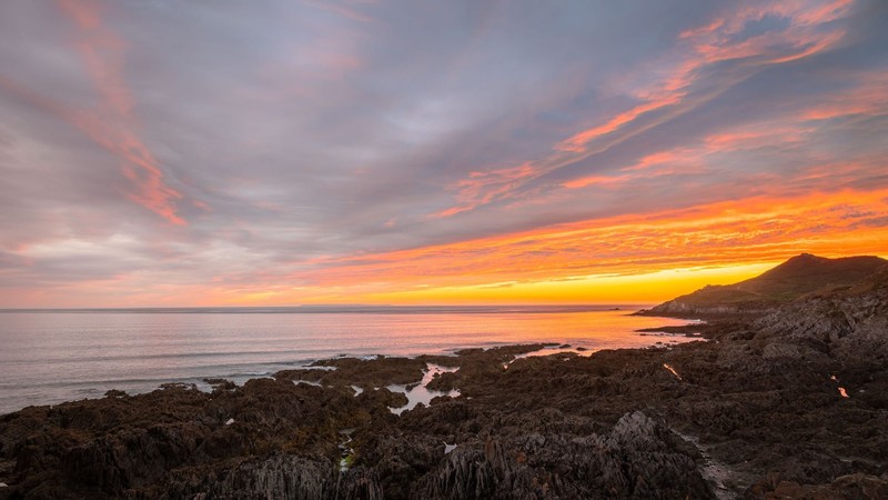 Am Strand von Woolacombe in England kannst du es dir gemütlich machen oder im Meer surfen gehen.